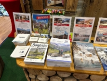 Prospektpräsentation am Messestand Urlaub in den Alpen