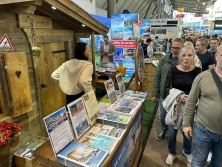 Prospektpräsentation am Messestand Urlaub in den Alpen