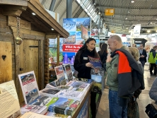 Prospektpräsentation am Messestand Urlaub in den Alpen