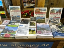 Prospektpräsentation am Messestand Urlaub in den Alpen