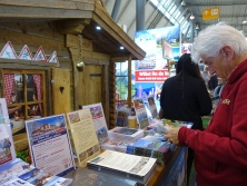 Prospektpräsentation am Messestand Urlaub in den Alpen