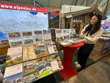 Prospektpräsentation am Messestand Urlaub in den Alpen