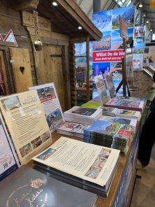 Prospektpräsentation am Messestand Urlaub in den Alpen