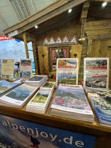 Prospektpräsentation am Messestand Urlaub in den Alpen