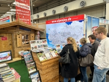 Prospektpräsentation am Messestand Urlaub in den Alpen