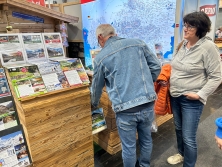 Prospektpräsentation am Messestand Urlaub in den Alpen