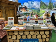 Prospektpräsentation am Messestand Urlaub in den Alpen