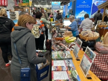 Prospektpräsentation am Messestand Urlaub in den Alpen